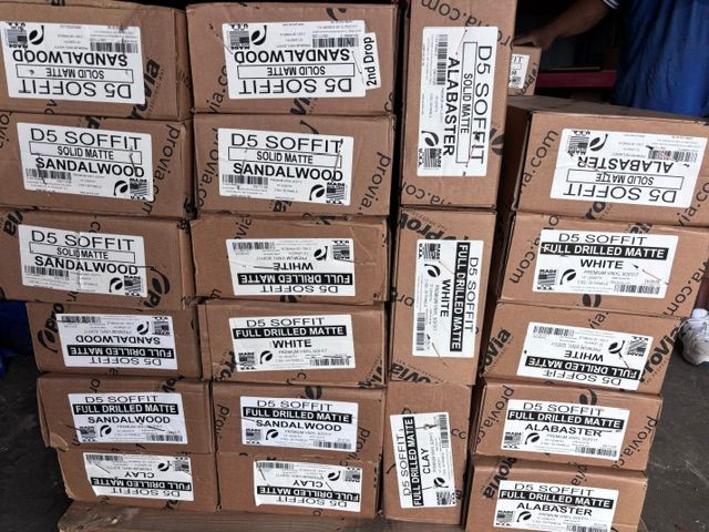 Stacked cardboard boxes with white shipping labels in a warehouse or storage area