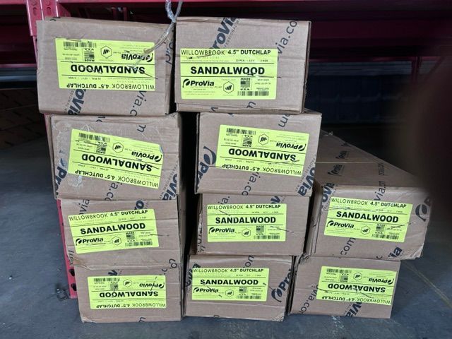 Stacked cardboard boxes labeled sandalwood and oom tyvosn in a shop aisle