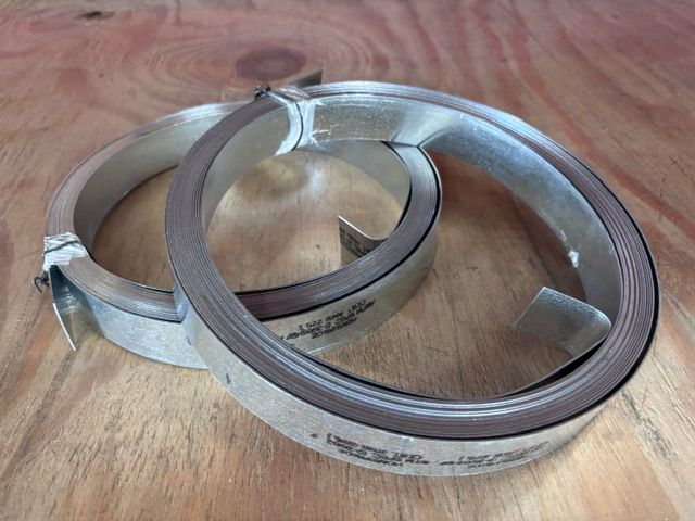 Coiled silver metal rings on a wooden surface