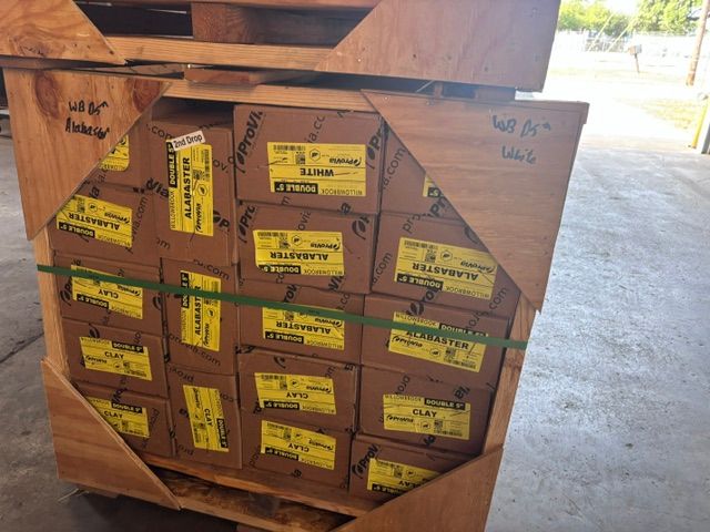 Wooden crate packed with yellow-labeled boxes, wrapped in cardboard and straps in a warehouse.