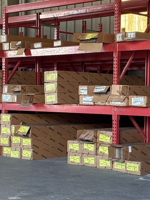 Warehouse shelves stacked with brown boxes and yellow-labeled packages