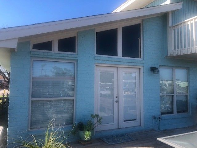 a blue house with a balcony and lots of windows | Corpus Christi, TX | GT Roofing