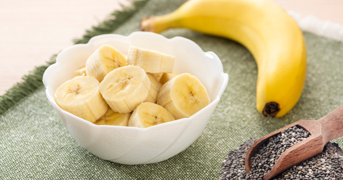 A bowl of sliced bananas next to a banana and hemp seeds.