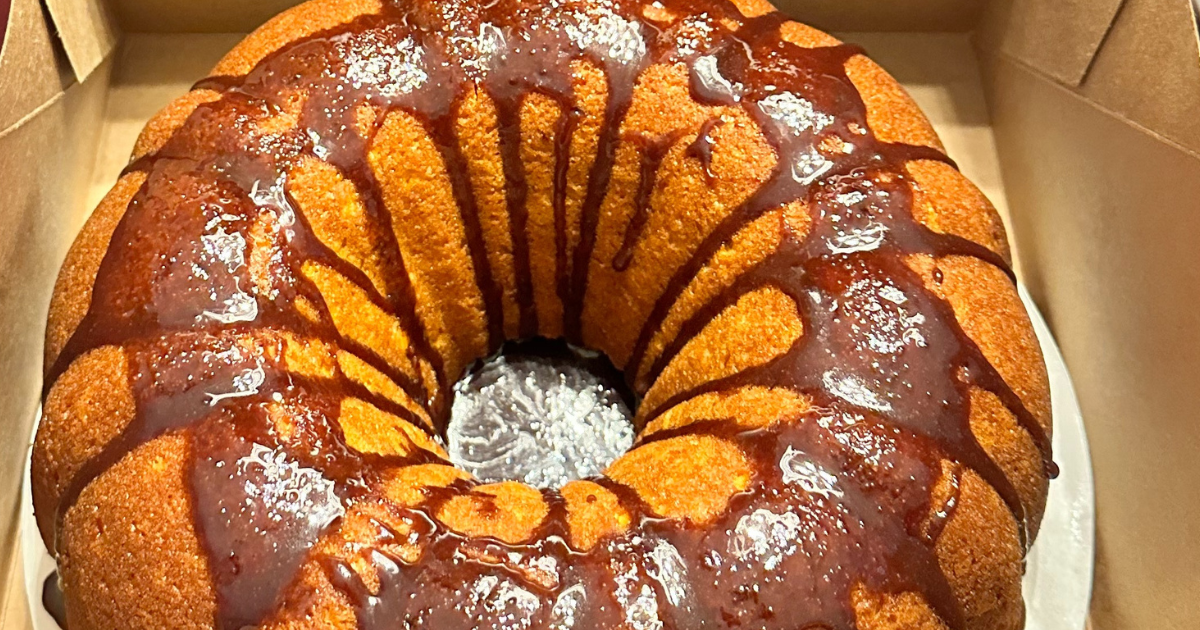 A bundt cake with chocolate icing is in a box.