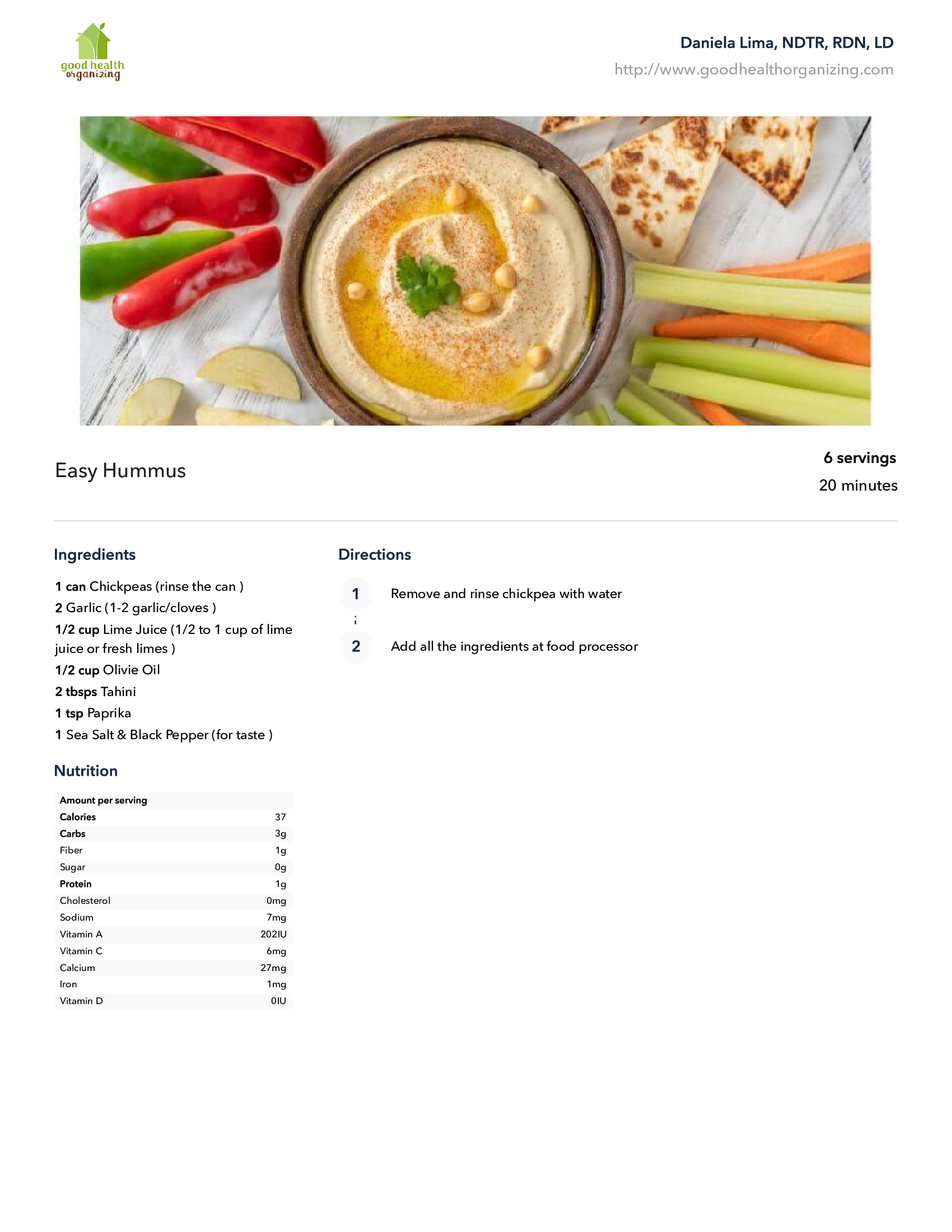 A bowl of hummus surrounded by vegetables on a table.