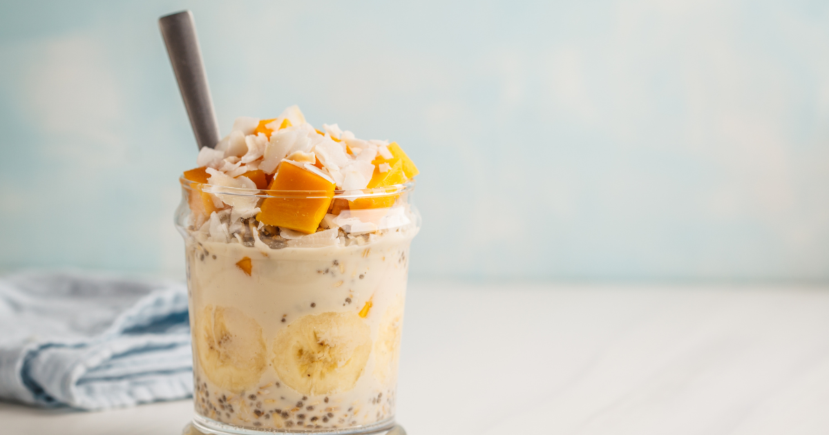 A close up of a smoothie in a glass with a straw.