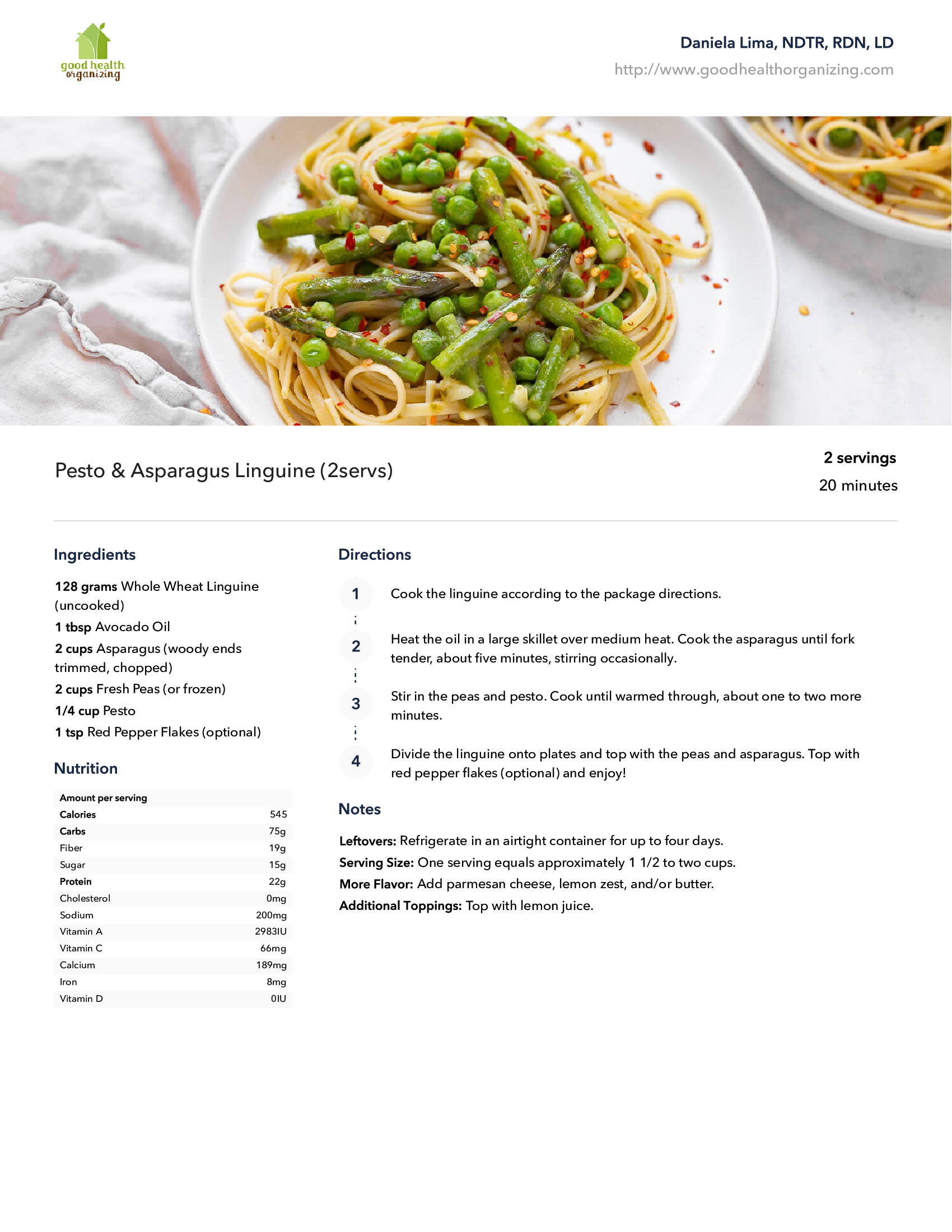 A plate of spaghetti with asparagus and peas on a table.