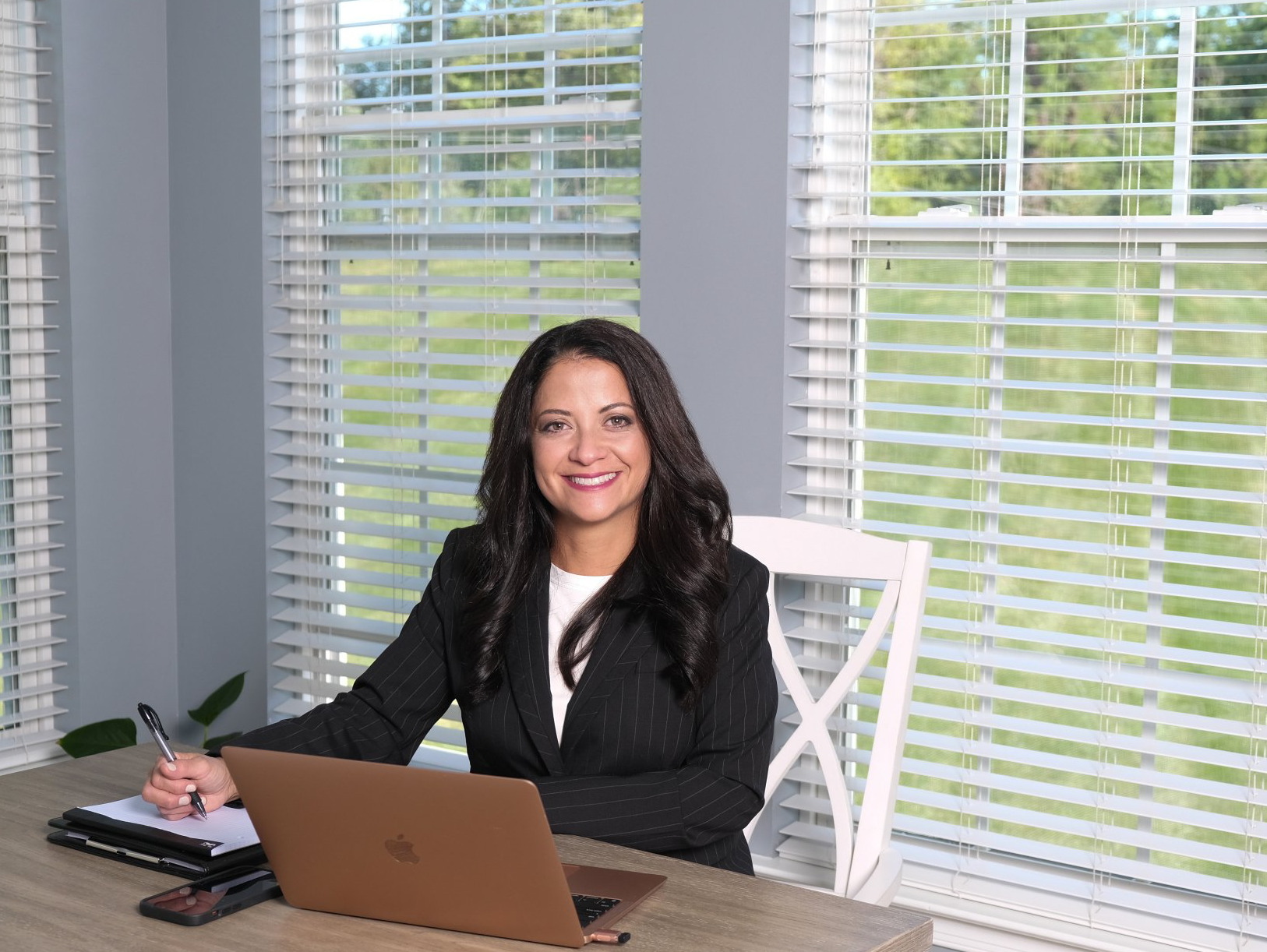 A woman is sitting at a desk with a laptop computer.