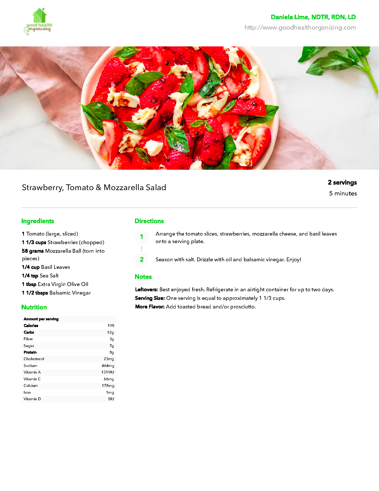 A plate of food with strawberries and basil on a table.