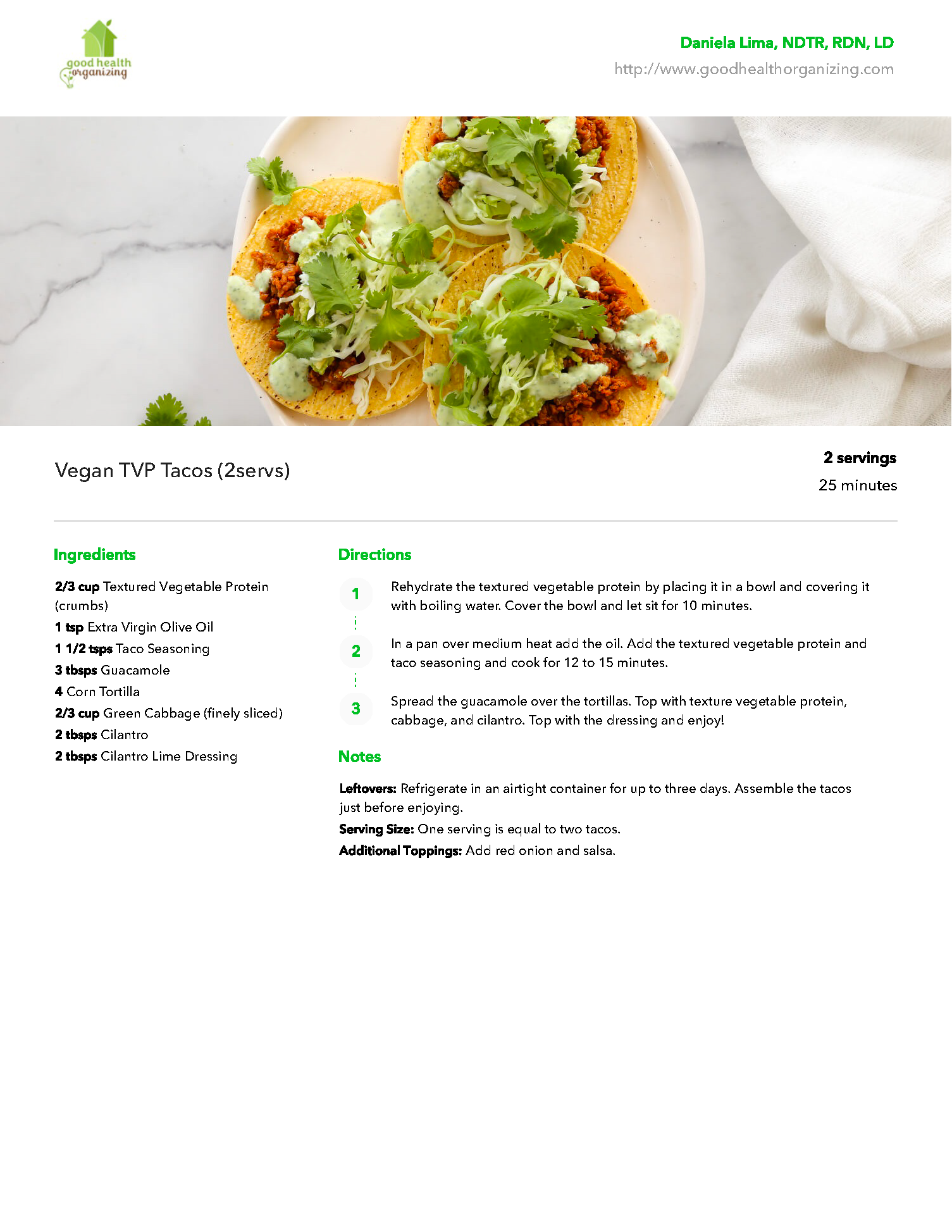 A white plate topped with tacos and greens on a table.