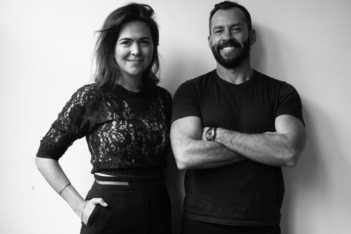 A man and a woman are standing next to each other with their arms crossed.