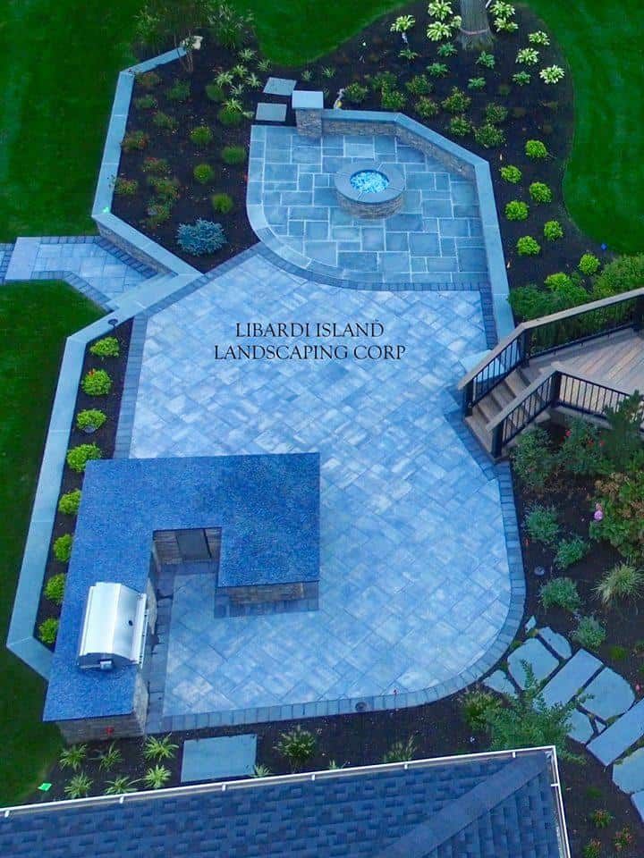 An aerial view of a patio with a grill and a fire pit