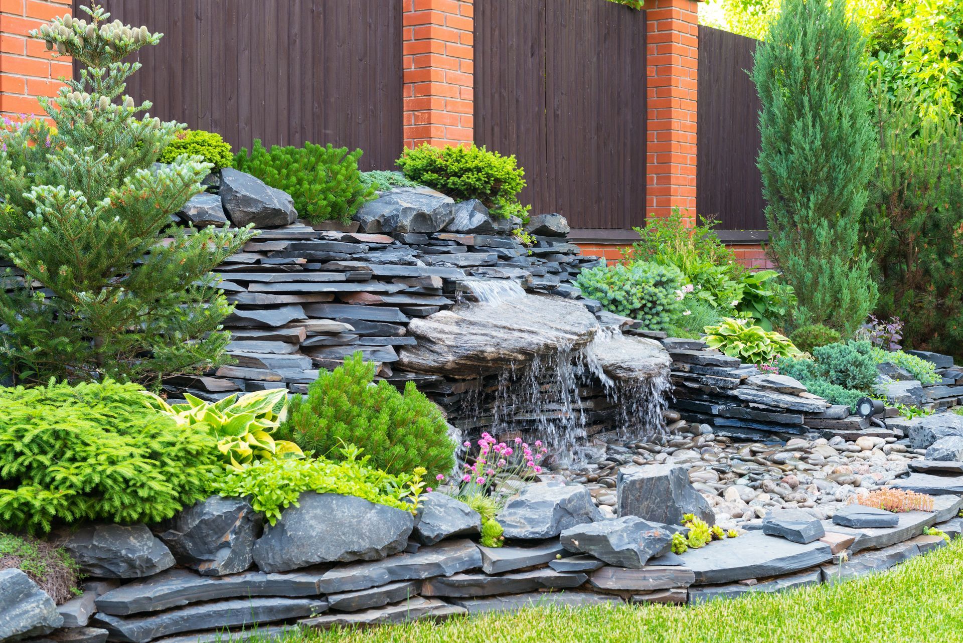 There is a waterfall in the middle of the rock garden.