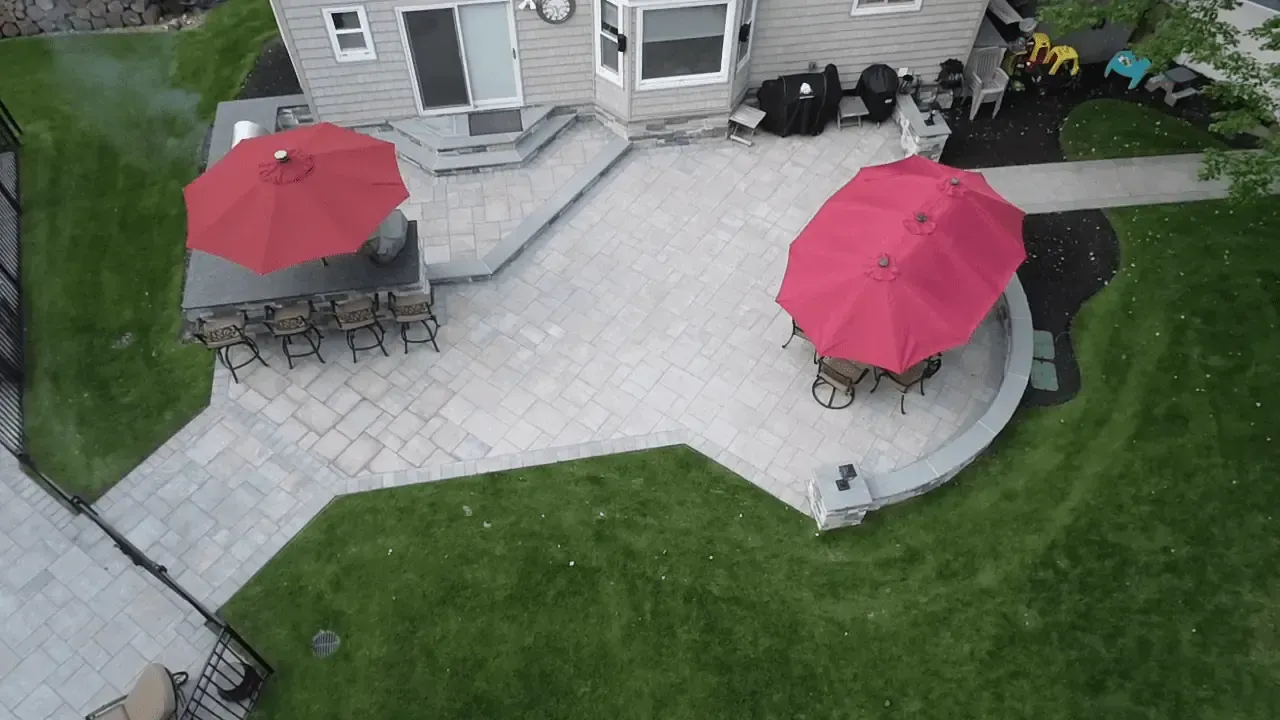 An aerial view of a patio with red umbrellas and tables.