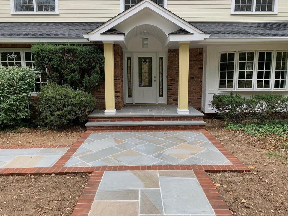 A house with a brick walkway leading to the front door