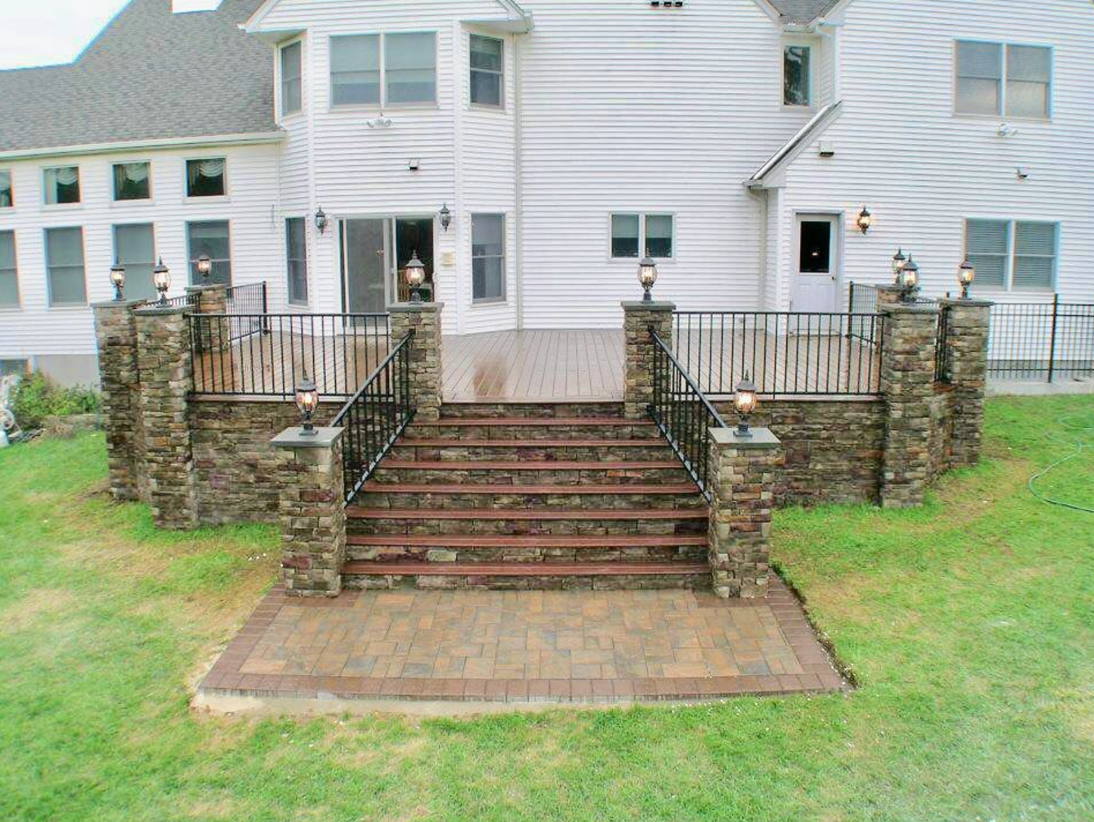 A white house with a patio and stairs in front of it