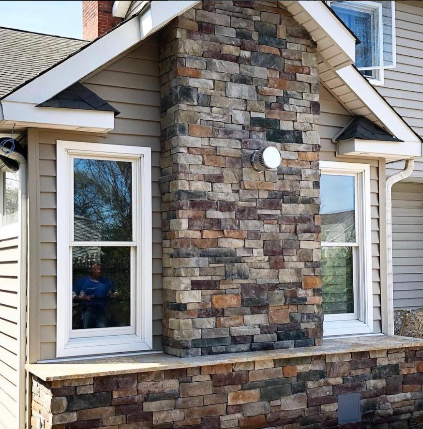 Commitment to Excellence A house with a stone chimney and two windows