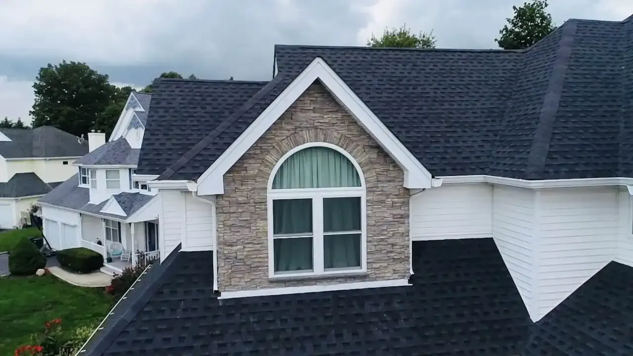 Stone Veneer An aerial view of a house with a window on the roof.