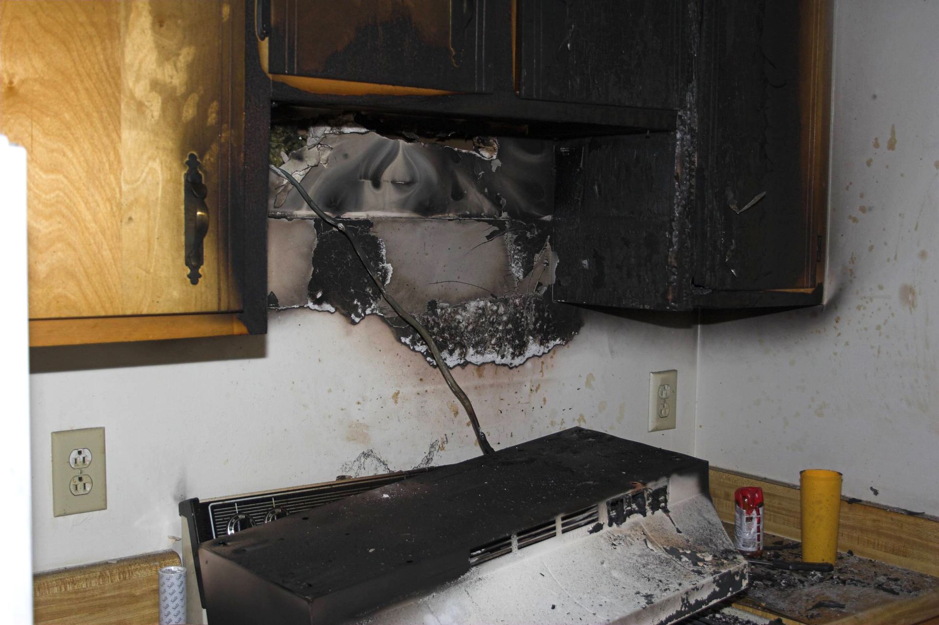 A kitchen with a stove that has been damaged by a fire
