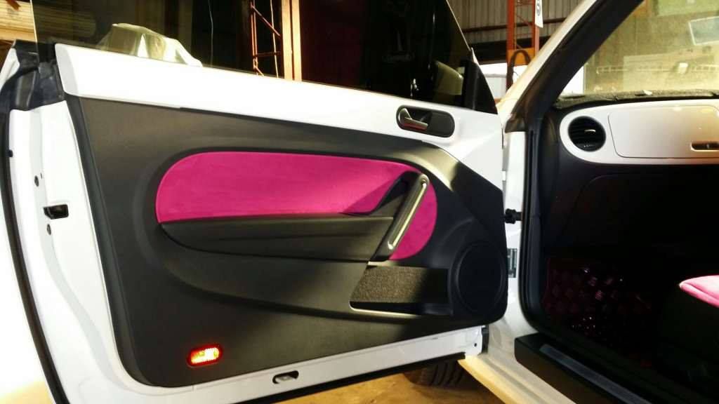 A White Car With Pink Door Panels is Parked in a Garage — Custom Unique Trimming in Mackay, QLD