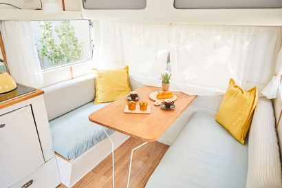 A Camper With a Table and a Couch in It — Custom Unique Trimming in Mackay, QLD