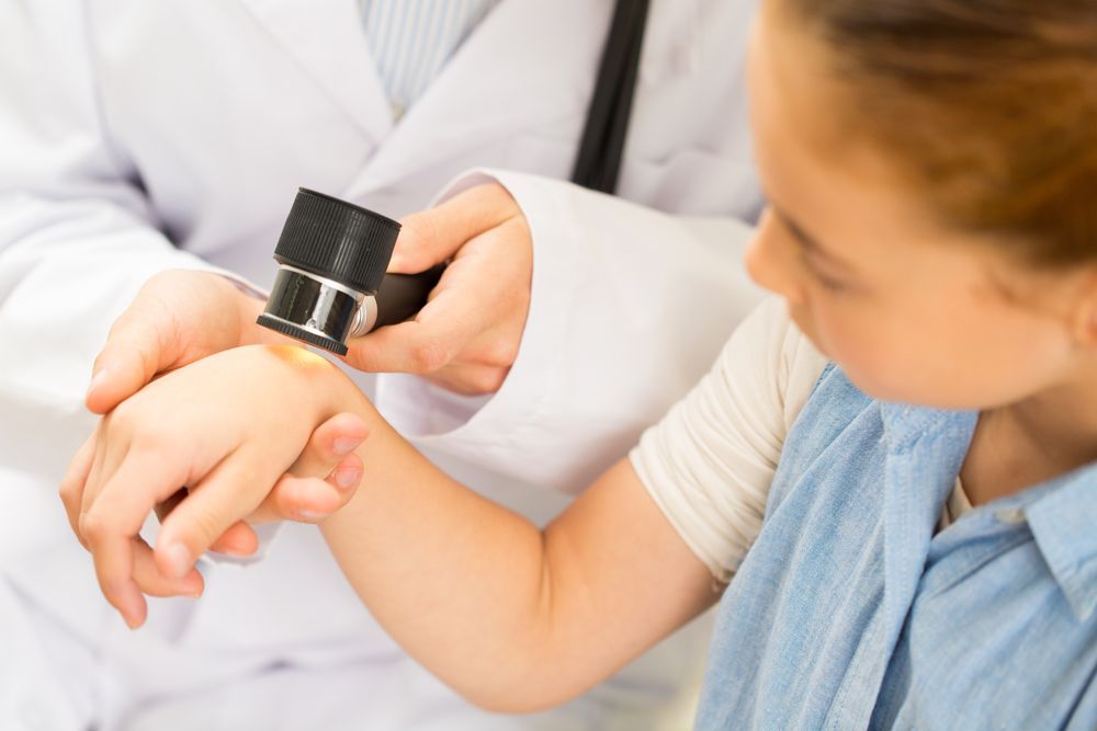 Doctor examining a patient's arm with a dermatoscope. — Bourbong Street Physiotherapy Centre in Bundaberg West, QLD