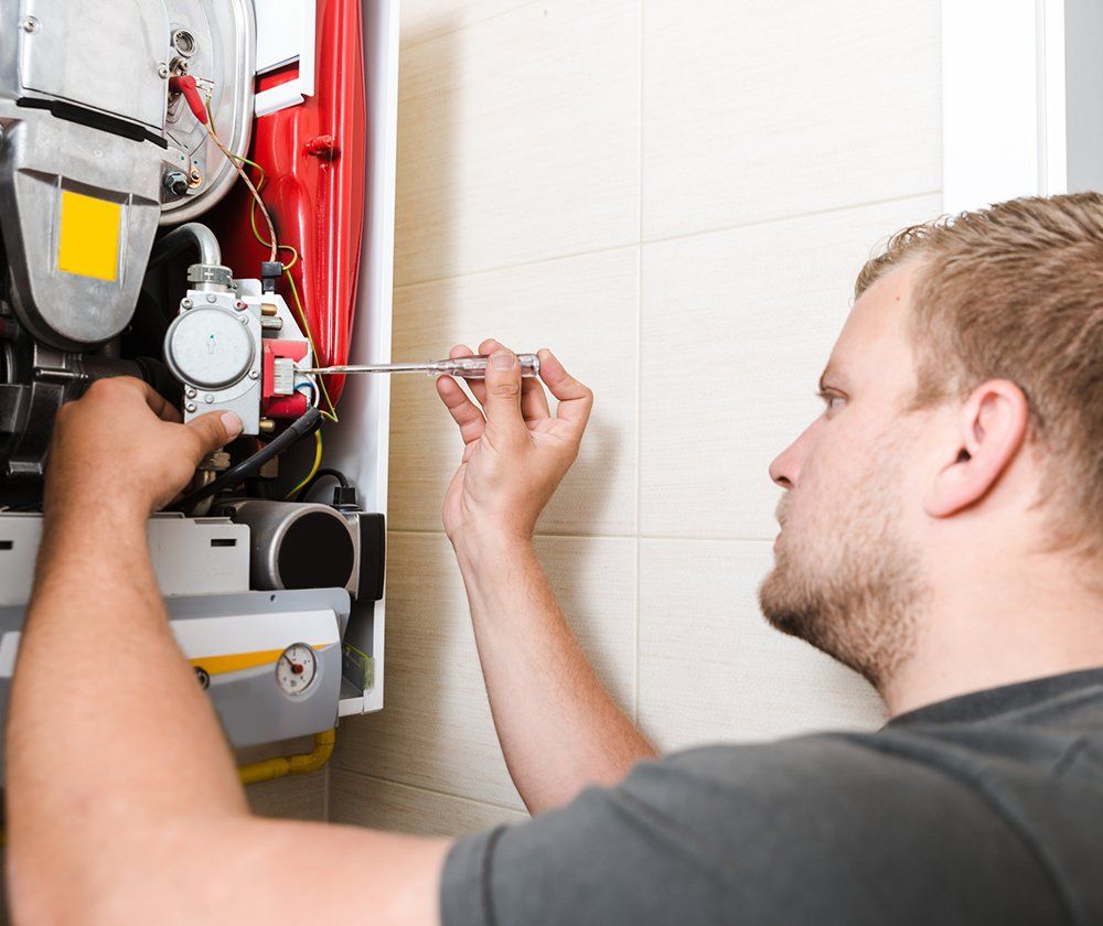 Worker Fixing The Heater — Weatherford, TX — Texas Air Conditioning & Heating