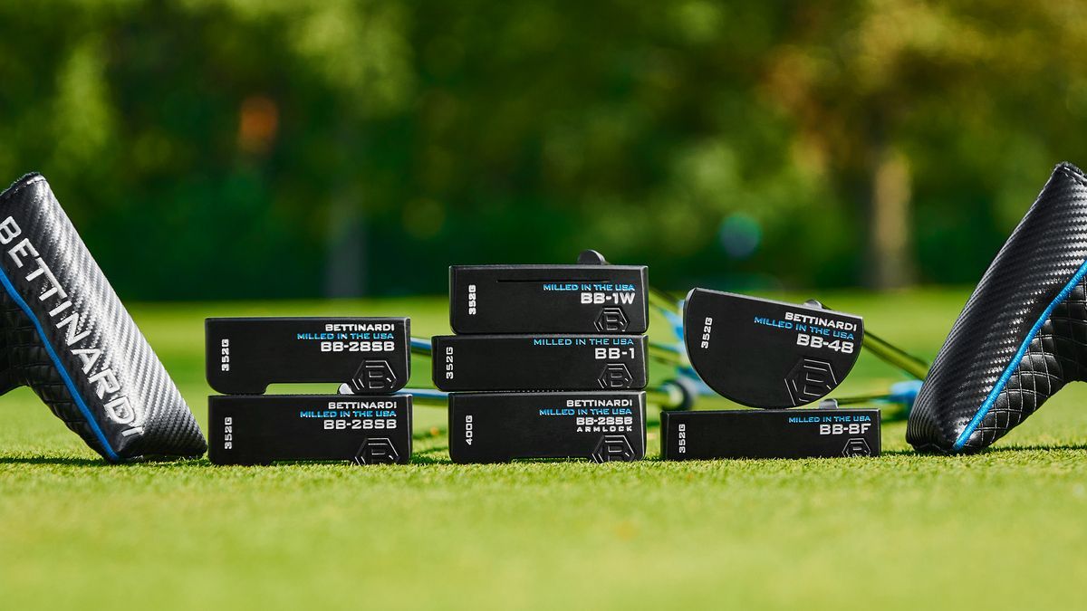 A group of golf clubs are stacked on top of each other on a green.