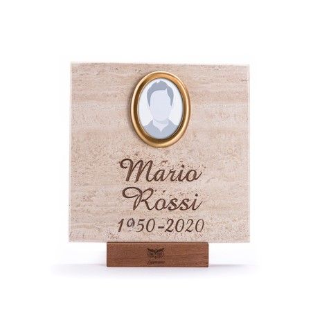 Una targa commemorativa quadrata in pietra con una cornice ovale centrale per una foto, il nome