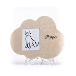 Una targa beige a forma di nuvola su un supporto trasparente, con un semplice disegno di un cane e il nome