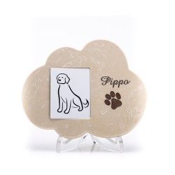 Un monumento commemorativo per animali domestici in pietra beige a forma di nuvola, con uno spazio per una foto, il nome