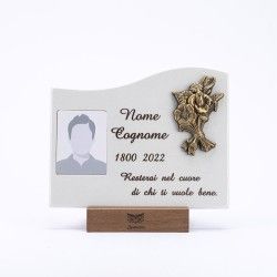 Una targa commemorativa su base di legno con cornice portafoto vuota, spazio per un nome, date e un'iscrizione commemorativa in italiano.