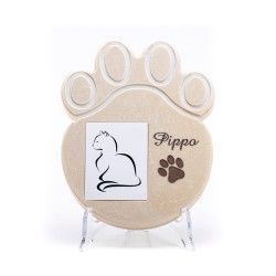 Una targa commemorativa per animali domestici di colore beige, a forma di zampa, con la sagoma di un gatto, il nome