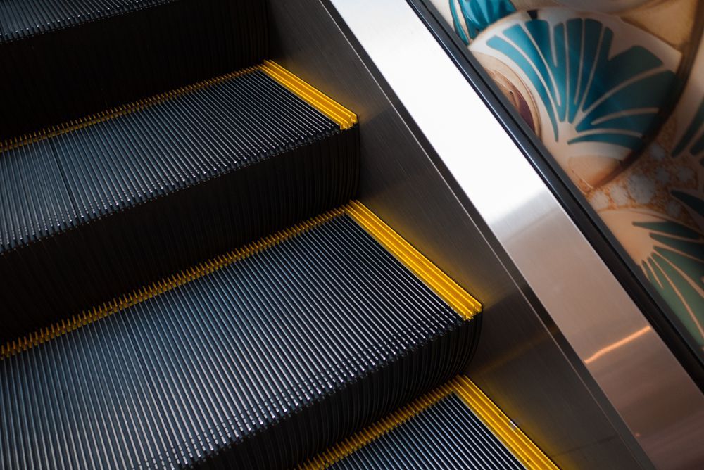 A close up of an escalator with a yellow border
