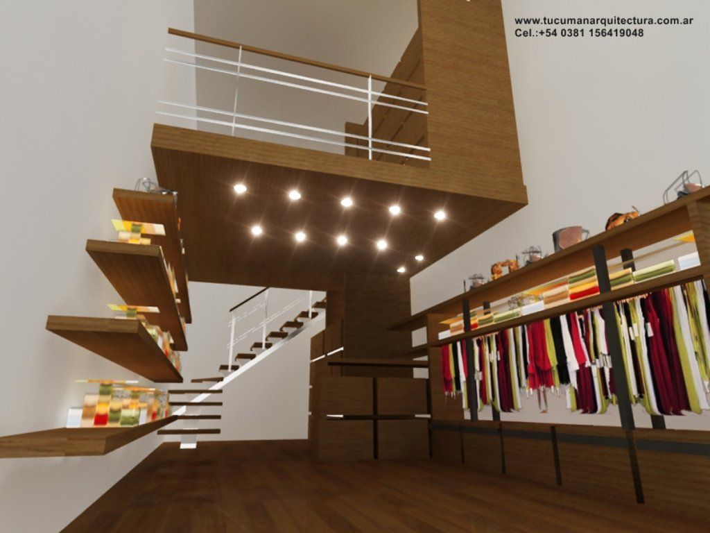 Interior de una moderna boutique de ropa con escaleras flotantes, luces cálidas y percheros con prendas coloridas.