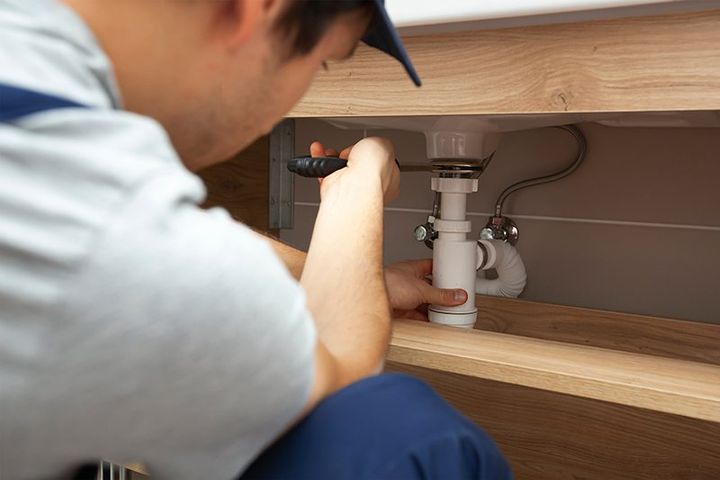 Plumber fixing the drain pipes