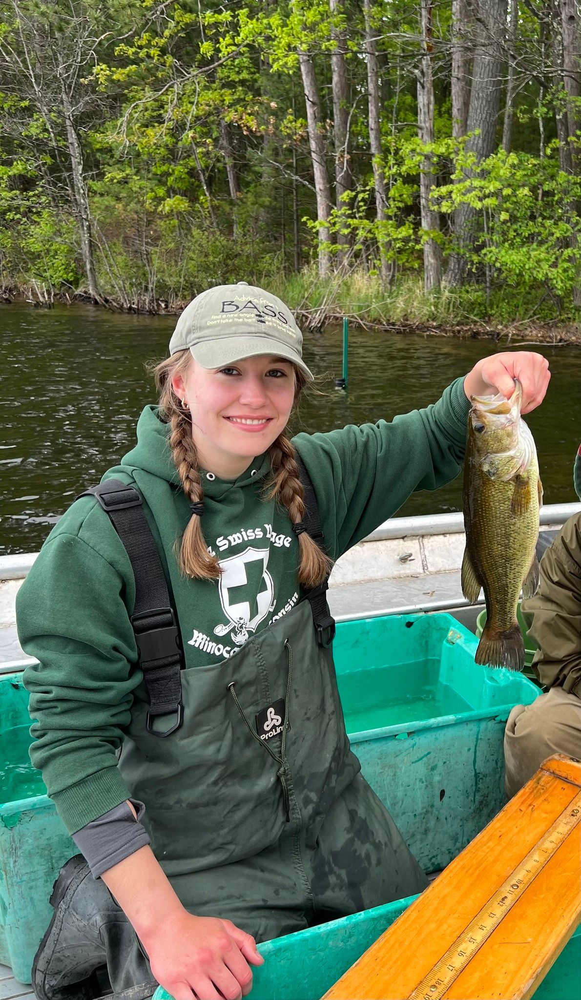 A woman is sitting in a boat holding a fish.