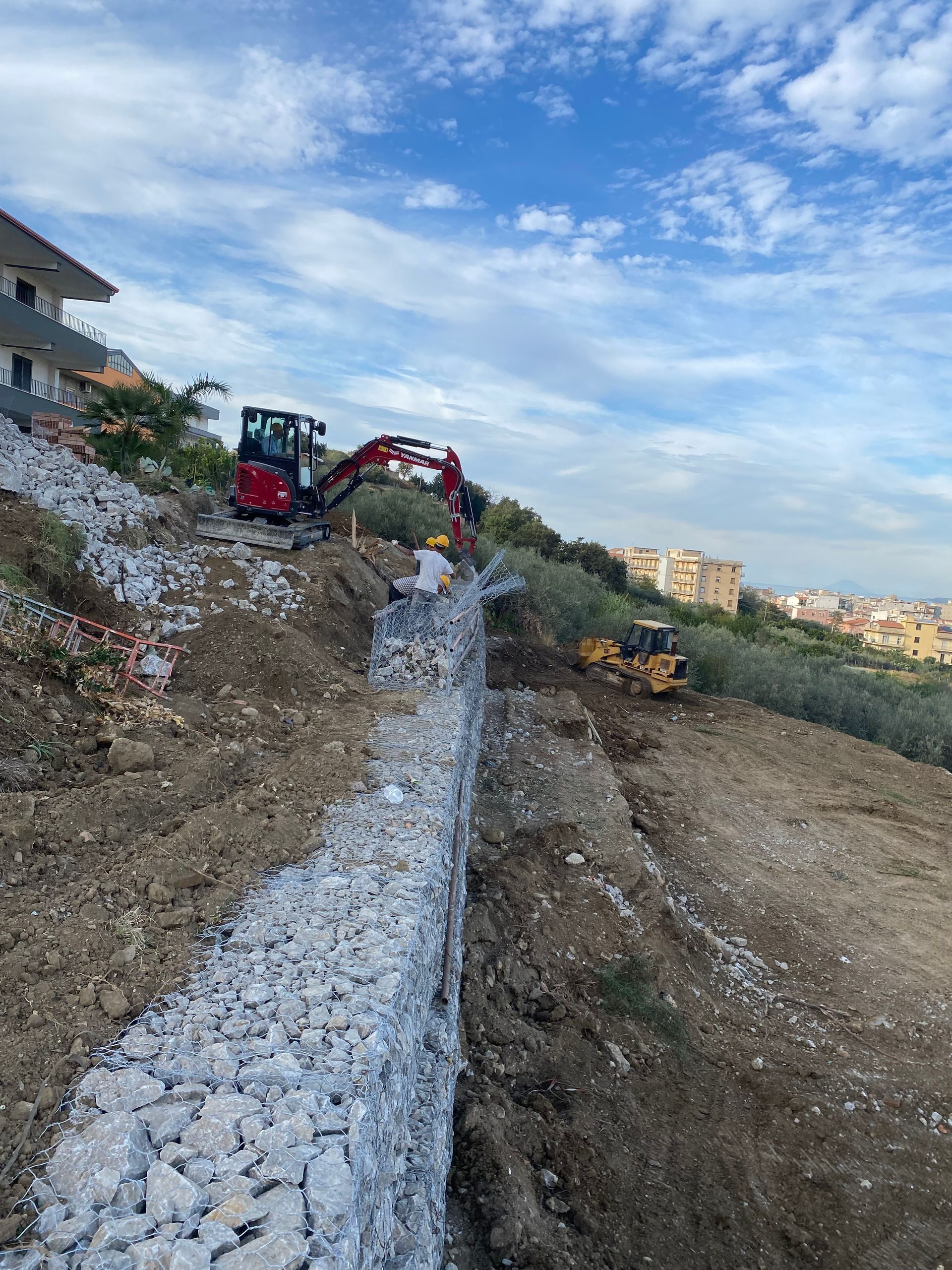 Un grande mucchio di rocce viene costruito in cima a una collina di terra.