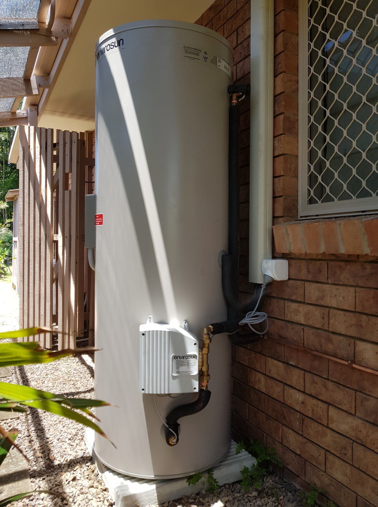 A Tall, Gray Water Heater Next to a Brick Wall — 24/7 Hot Water in Valdora, QLD