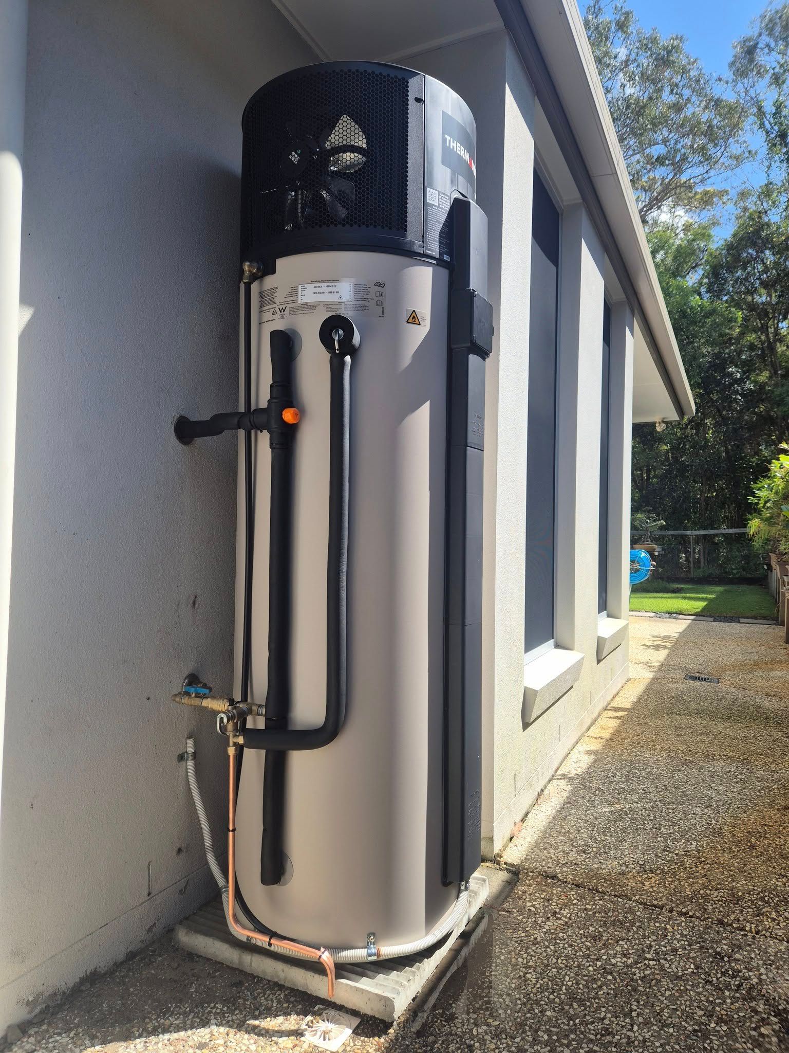 Outdoor Water Heater Unit Beside a House Wall — 24/7 Hot Water in Gympie, QLD