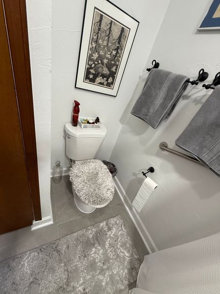 A modern bathroom with blue vanity cabinets, white marble countertops, a glass shower stall, and patterned floor tile. A modern bathroom with blue vanity cabinets, white marble countertops, a glass shower stall, and patterned floor tile.