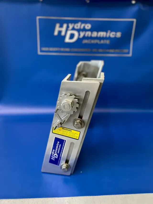 Hydro Dynamics metal mechanical component on a blue background with company logo backdrop