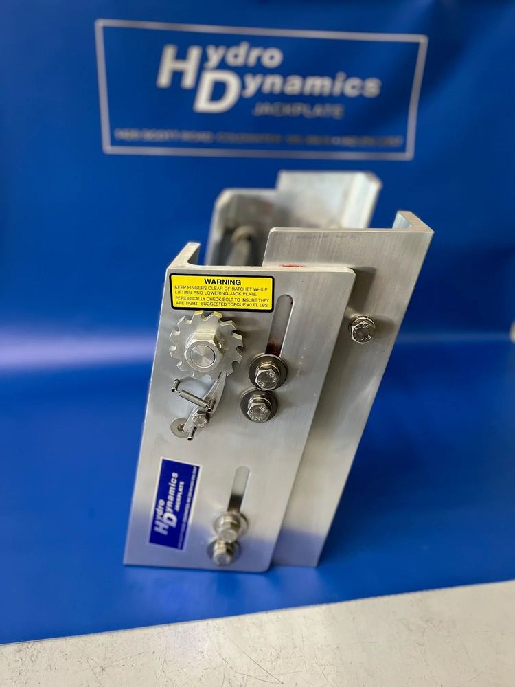 Stainless steel industrial valve component with yellow label on a blue Hydro Dynamics backdrop