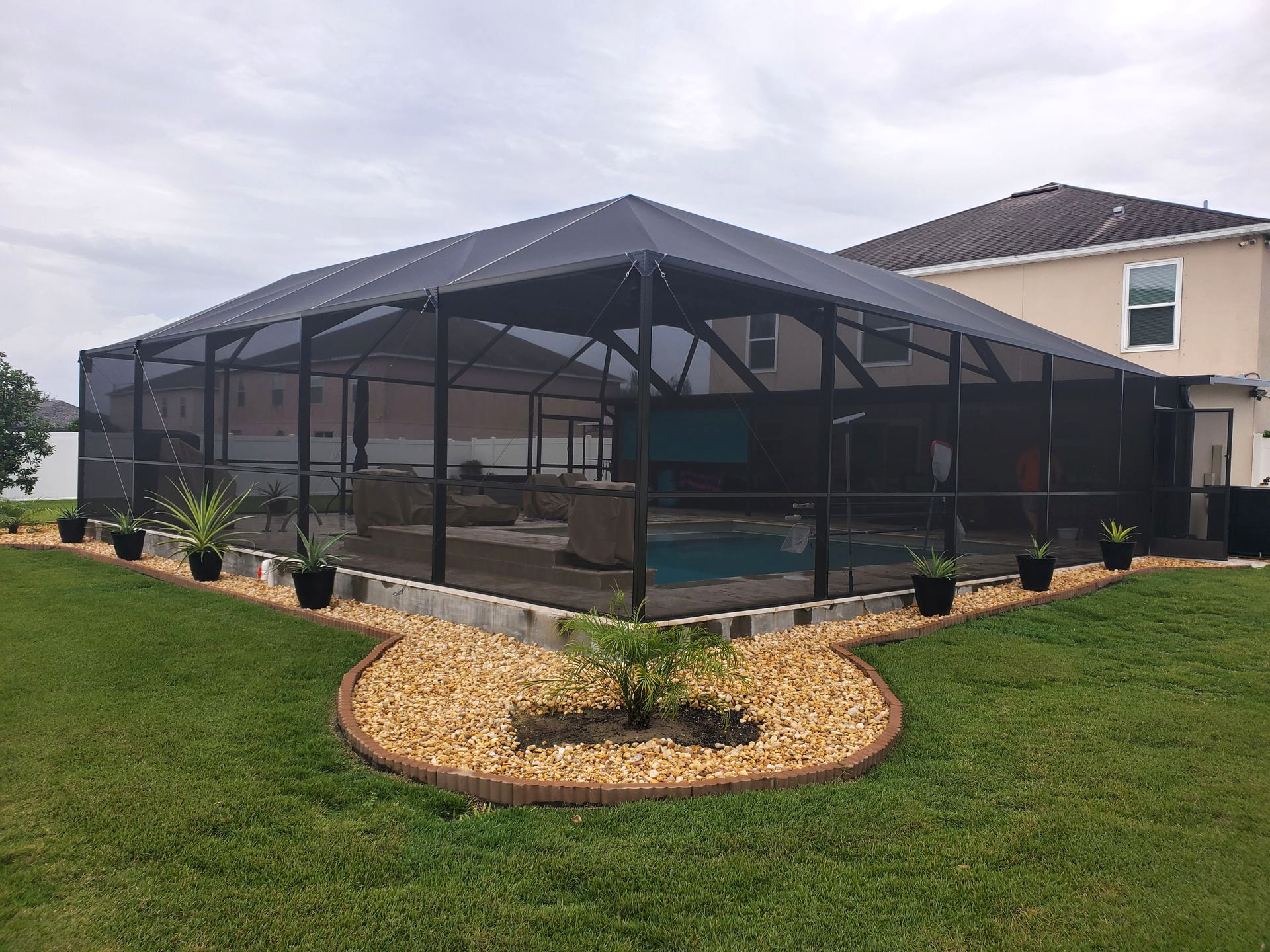 bronze hip roof pool enclosure with a split level installation in Lakeland, FL.