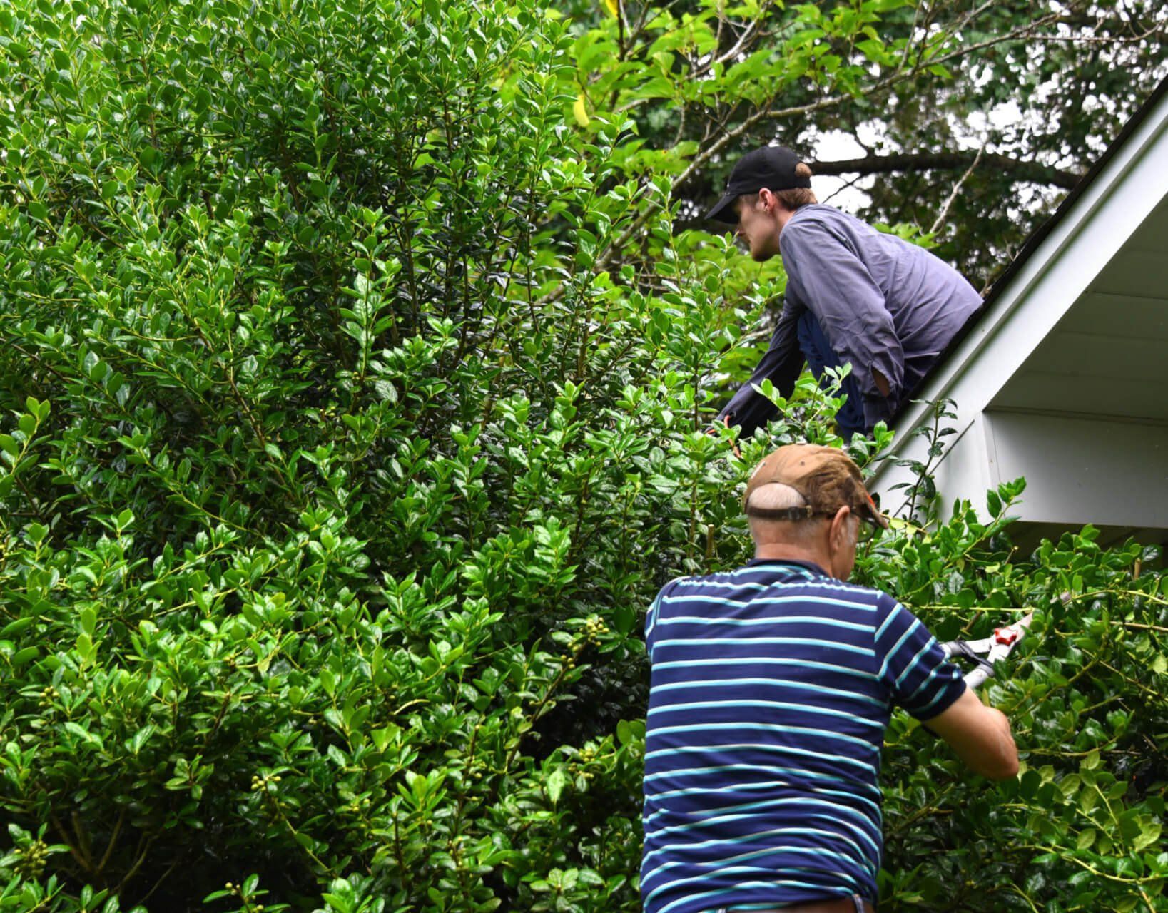 Two men are working on the roof of a house