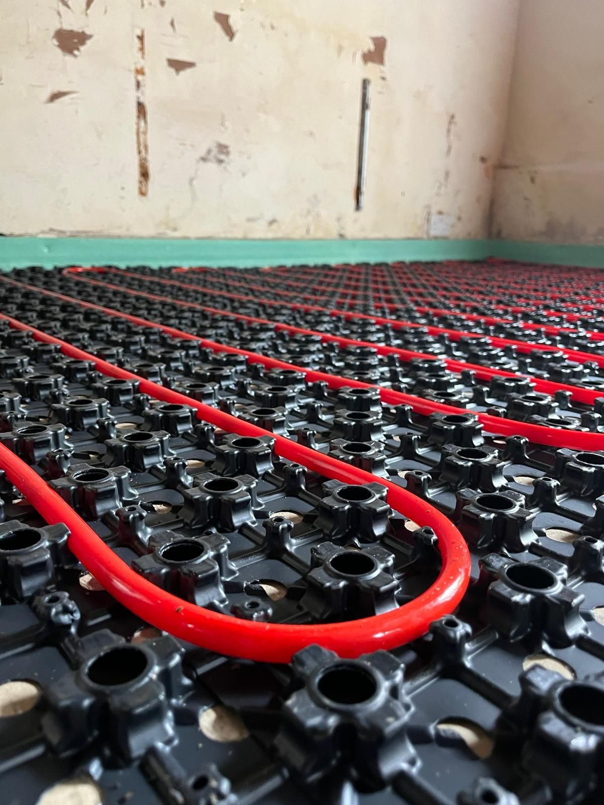 Heating engineer diagnosing underfloor heating problem with thermal scanner