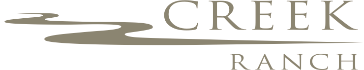 A logo for creek ranch with a river running through it.