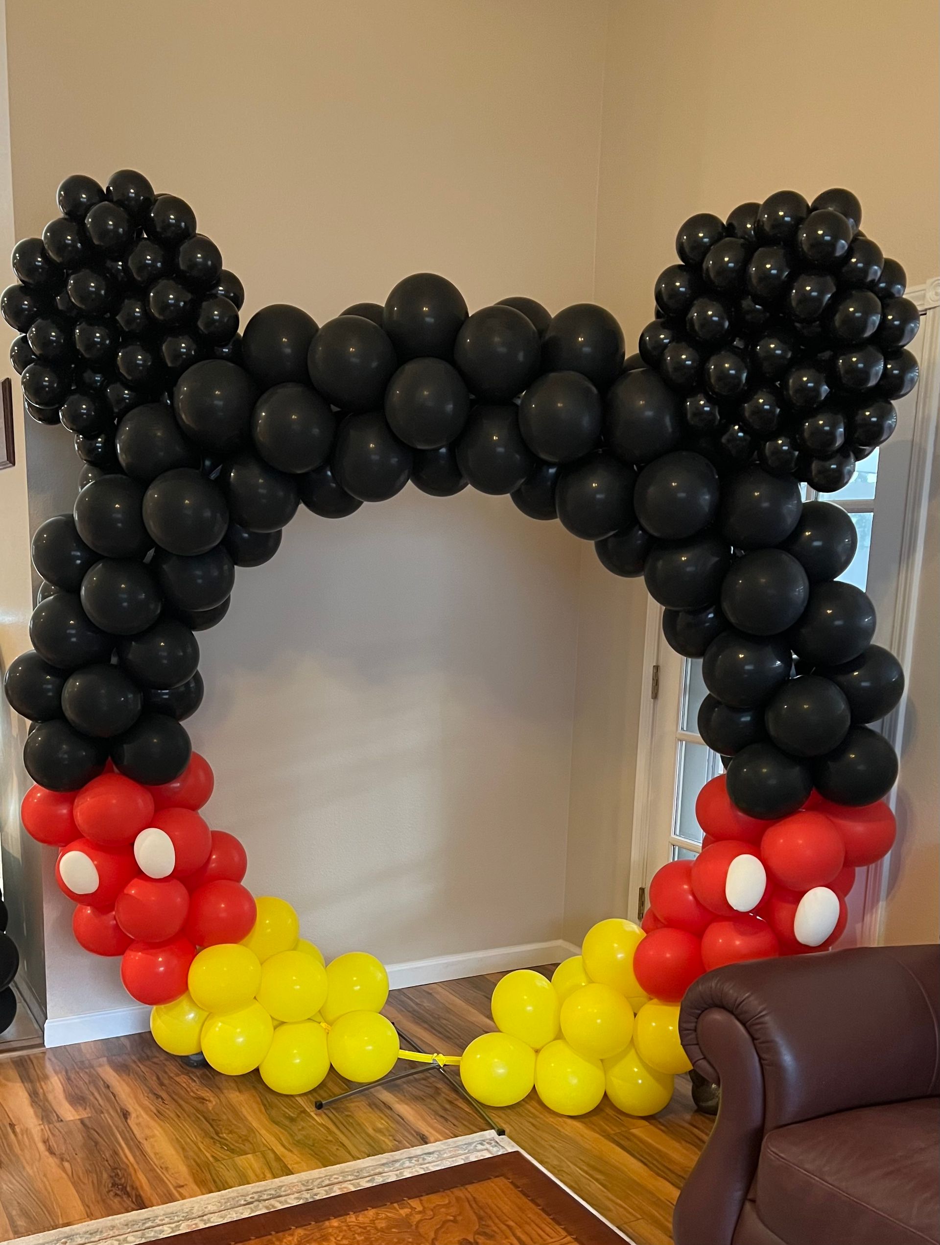 A room filled with balloons in the shape of mickey mouse ears.
