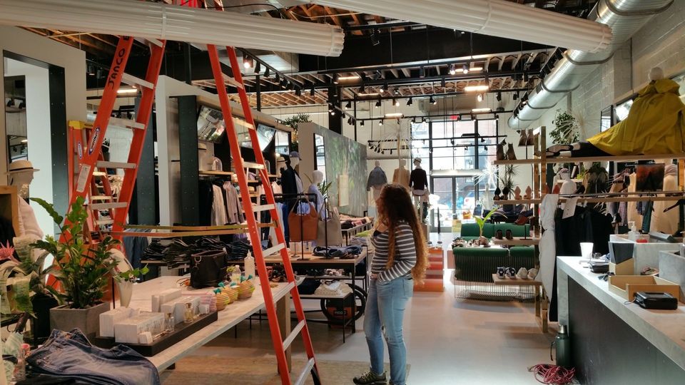 A woman is standing in a store with a ladder in the background.