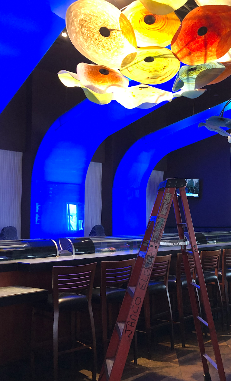 A ladder is sitting in front of a bar in a restaurant.